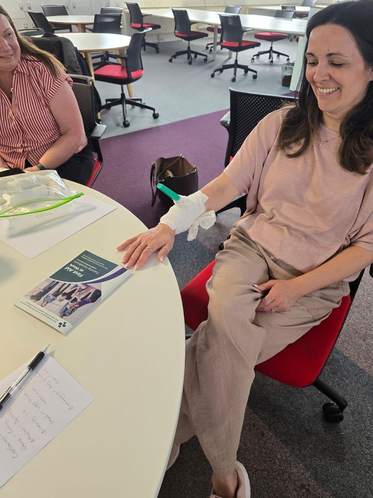 Delegate with a bandaged hand during first aid bandaging practice