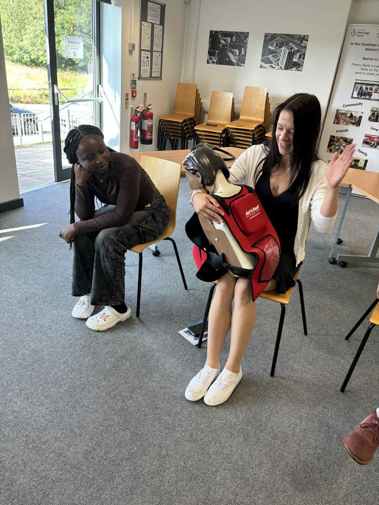 Trainer demonstrating choking first aid on a child training manikin