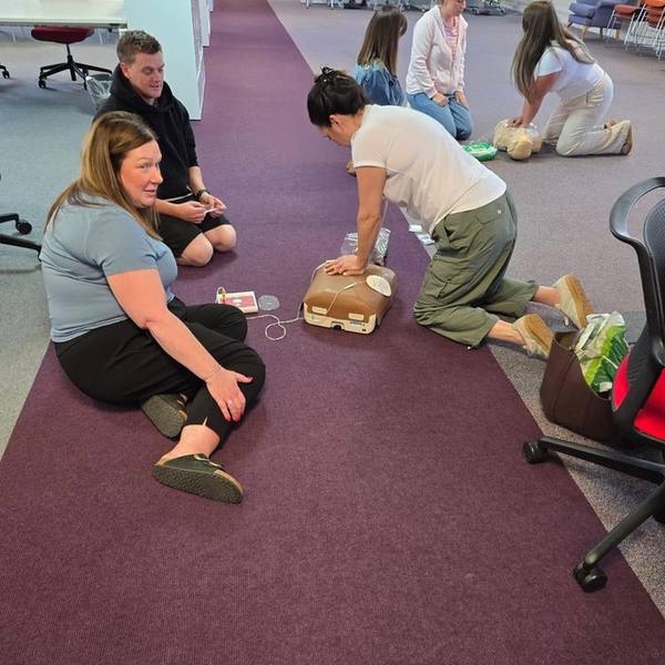 A group of employees practising CPR during an in-house first aid course