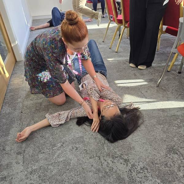 Placing a casualty into the recovery position during first aid training